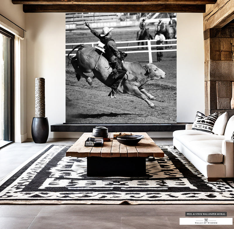 High contrast black and white mural of bull rider mid-air at rodeo.