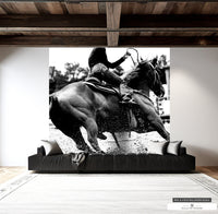 Black and white mural of a woman barrel racer at rodeo in dynamic action.