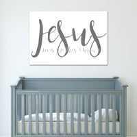 Gray crib with a 'Jesus Loves You This Much' sign on a white wall